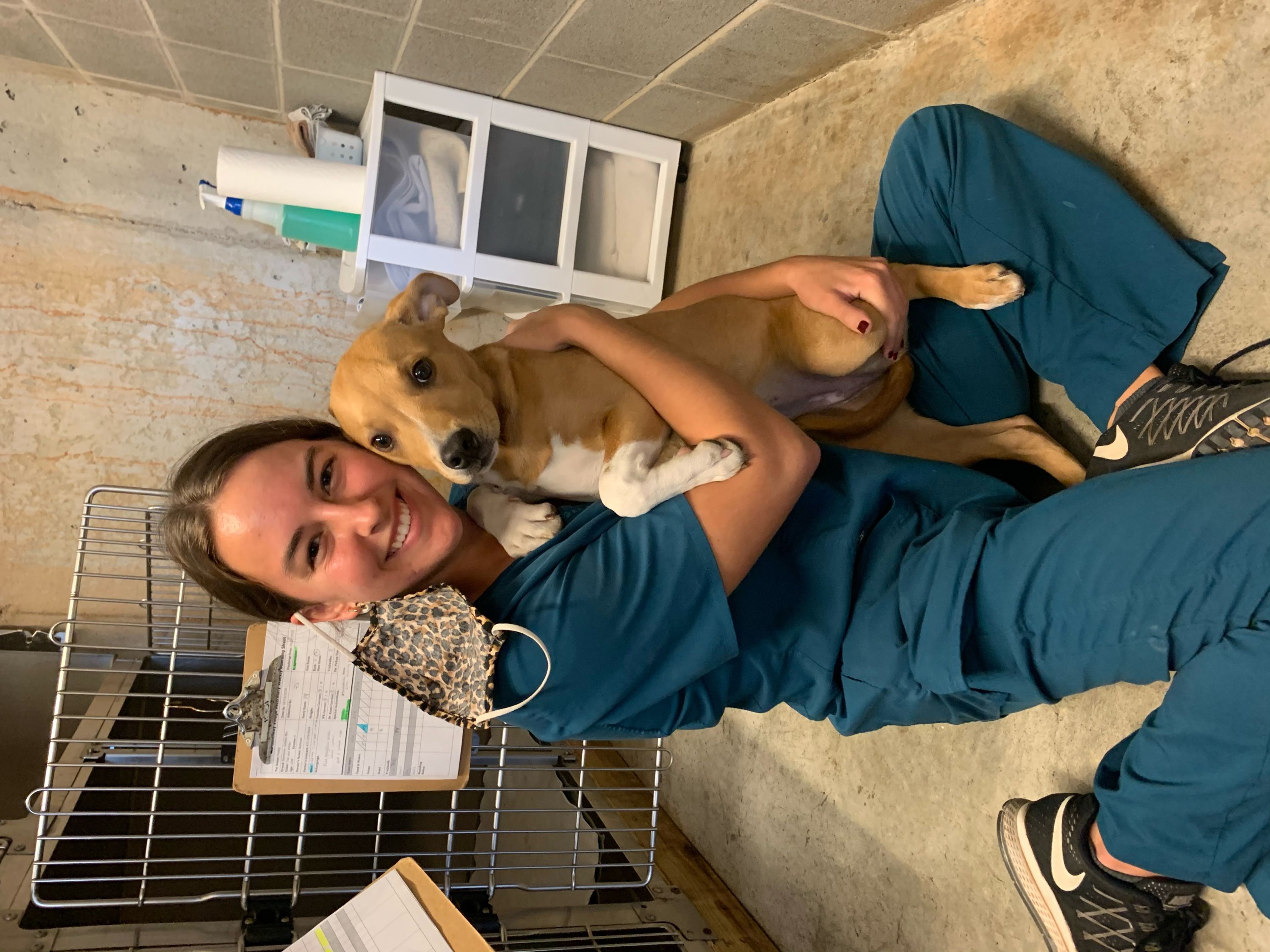 Kennel Technician Maddie Purvis cuddling with one of our daycare dogs